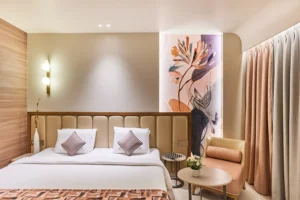 Hotel Tunga Regale luxury guest room in Andheri East, Mumbai, with a king-size bed, modern wood details, illuminated floral mural, soft ambient lighting, and contemporary furnishings.
