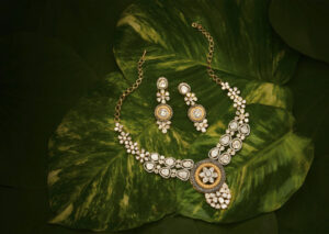 Traditional Indian diamond necklace and matching earrings set displayed on lush green leaves