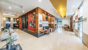 Modern Hotel GCC lobby with bright, spacious reception, comfortable seating, contemporary wood design, and well-lit welcoming ambiance.