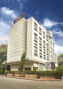 Modern exterior view of Hotel Bawa International in Mumbai with a clear blue sky.