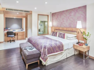 Spacious hotel room at Hotel Bawa International with a king-size bed, cozy seating, work desk, and stylish decor.