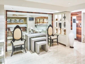 Elegant seating area and lounge at Hotel Bawa with contemporary chairs, decorative shelves, and marble flooring.