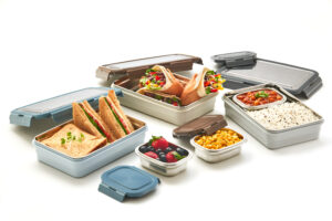 Pratap Plastic stainless steel lunchbox filled with cookies and dry fruits, placed on a wooden background.