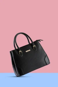 "Elegant black luxury tote handbag with gold hardware and textured finish, displayed on a pink and blue background for product photography".