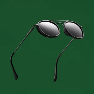 "Black designer aviator sunglasses with round lenses and thin metal frame, photographed on a green background in a floating position".