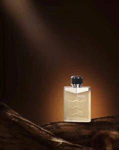 SKINN Titan Raw perfume bottle with chrome cap, placed on rustic wood against a dramatic brown background